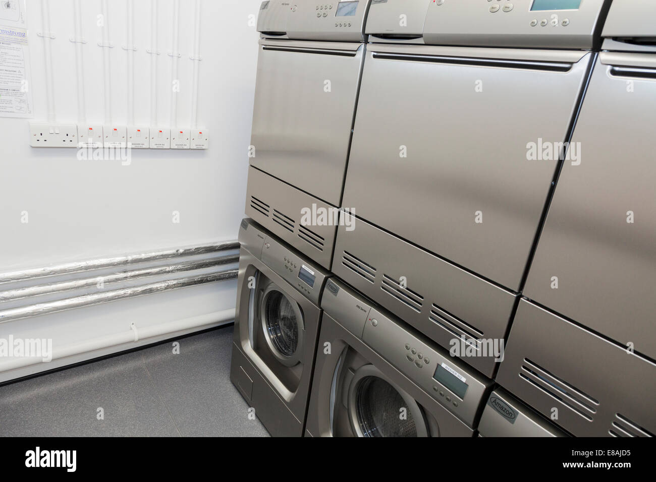 Lavatrici e asciugatrici in comune sala lavanderia. Foto Stock