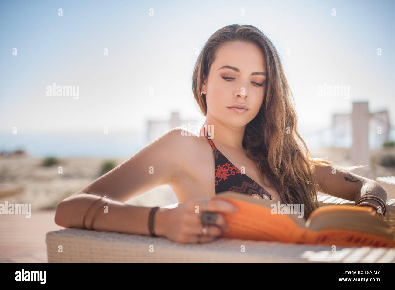 Giovane donna libro lettura in spiaggia, Castiadas, Sardegna, Italia Foto Stock