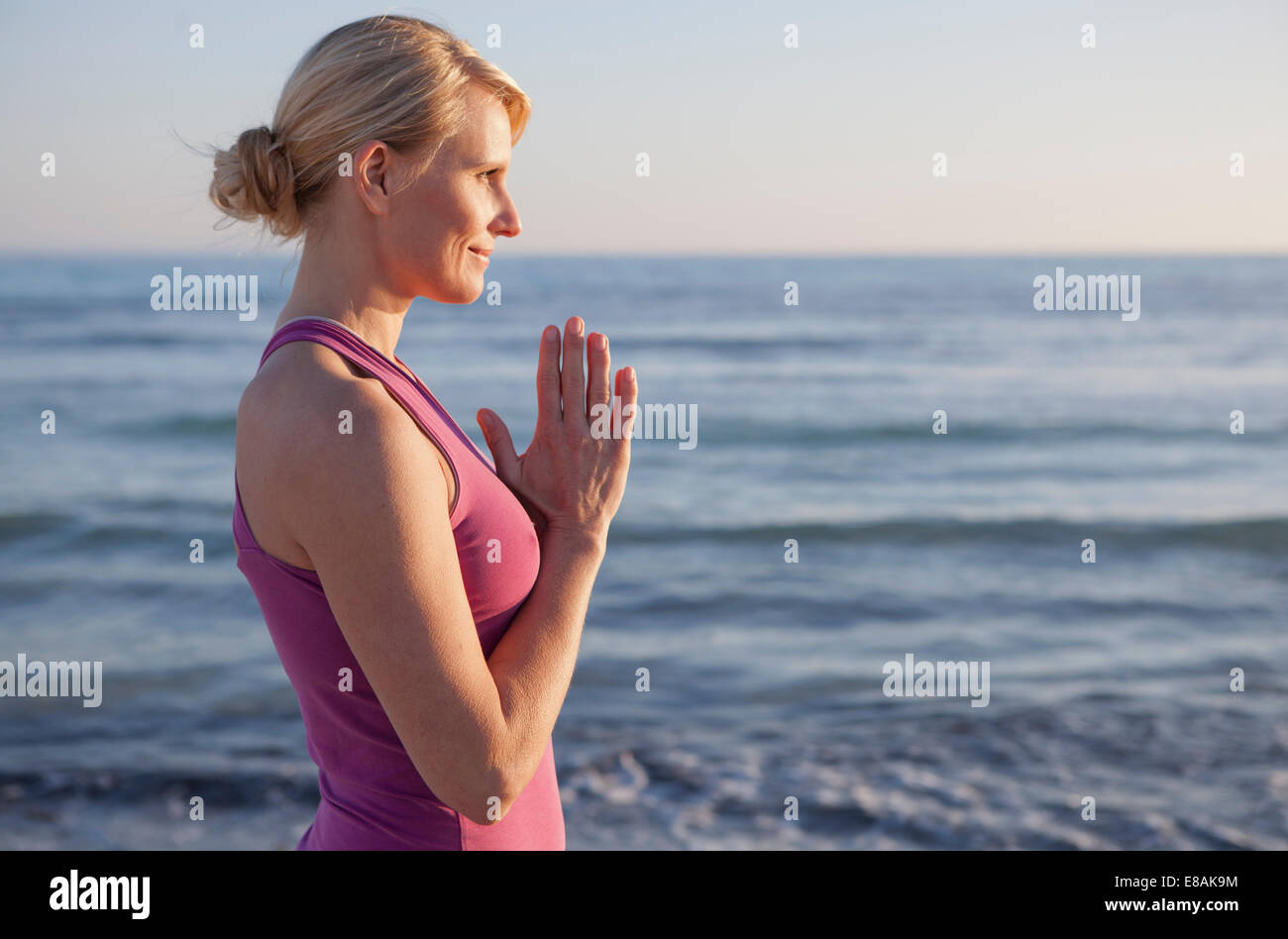 Donna in preghiera yoga pone sulla spiaggia Foto Stock