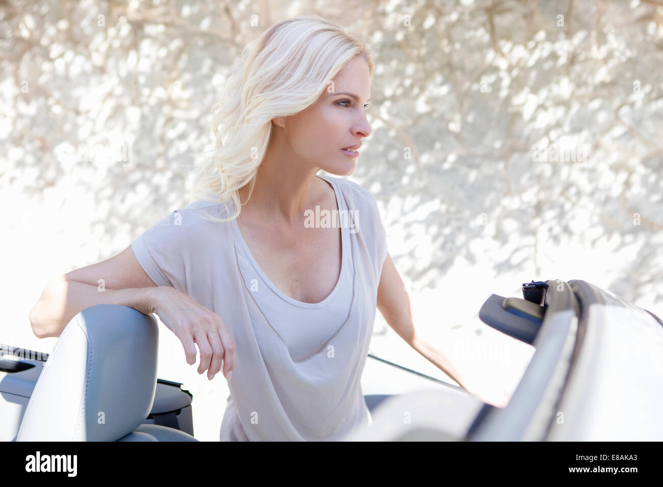 La donna accanto alla sua autovettura convertibile Foto Stock