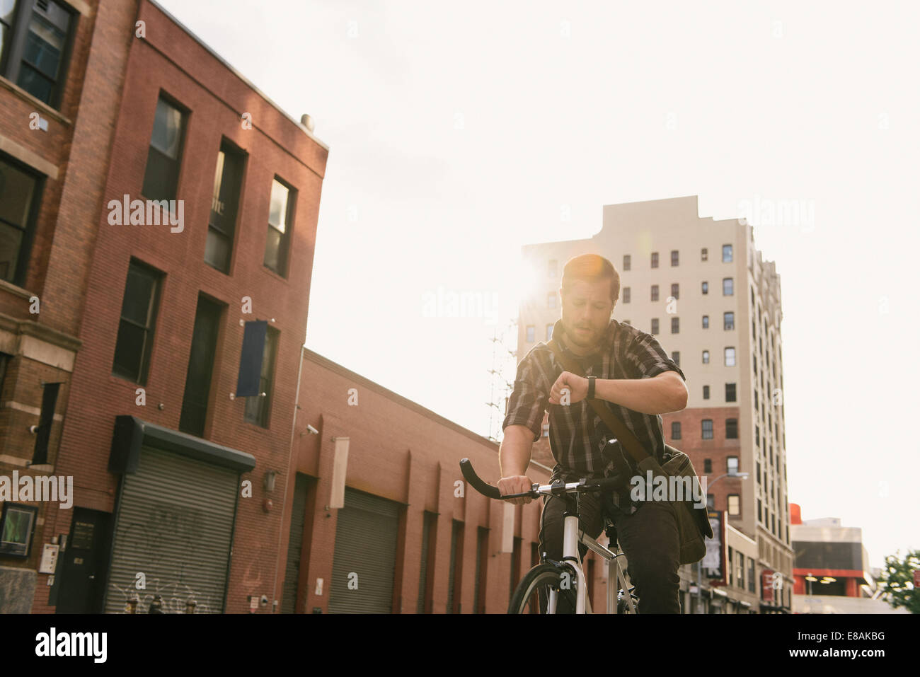 Ciclo maschio messenger controllo tempo su un orologio da polso Foto Stock