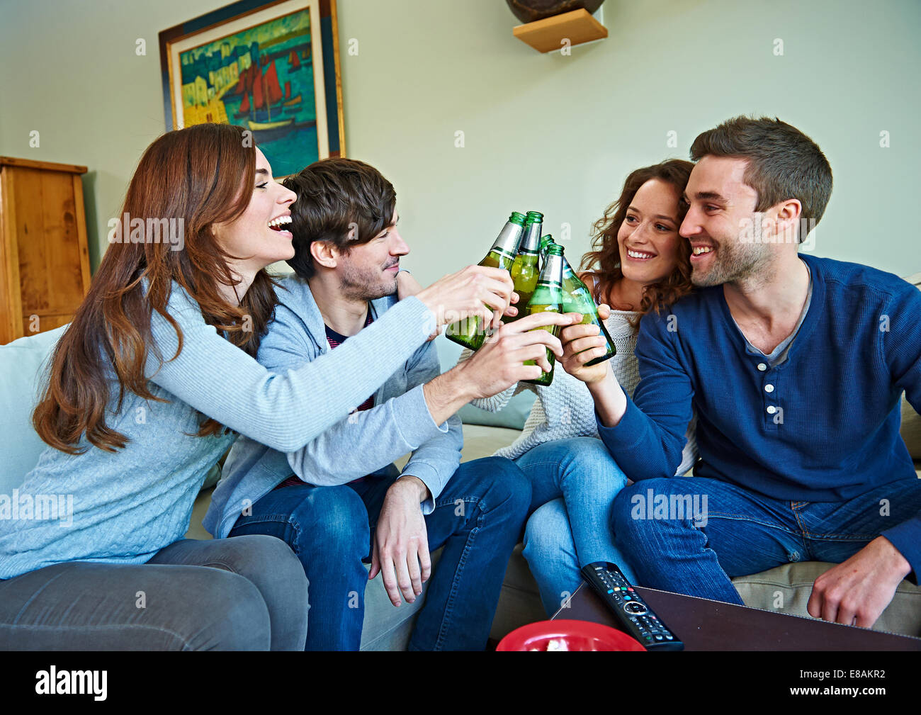 Gruppo di amici a guardare lo sport in salotto Foto Stock