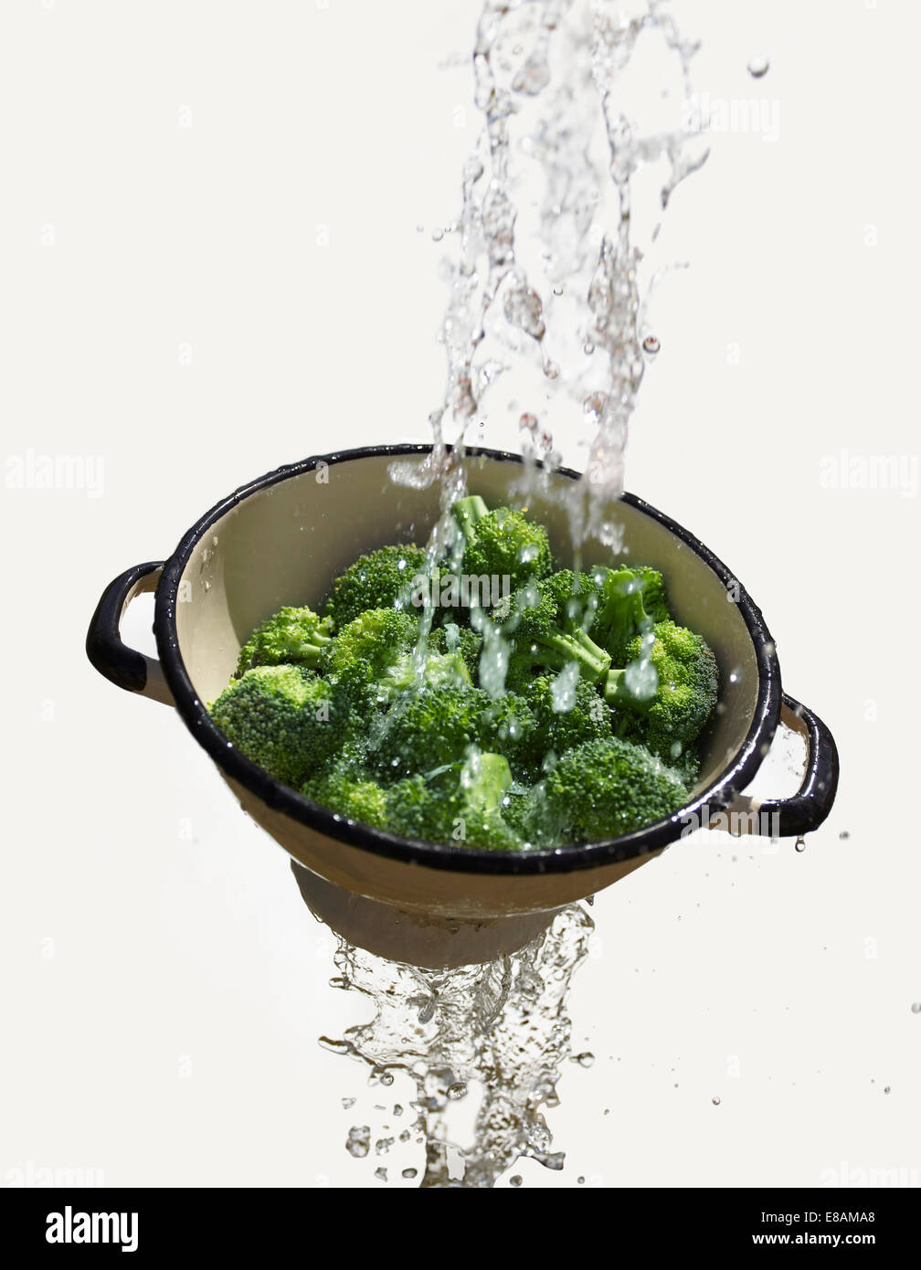 L'acqua che cade attraverso il colino con broccoli freschi Foto Stock