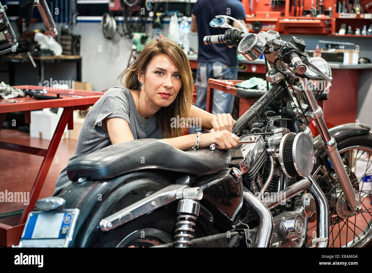 Ritratto di donna meccanico in officina del motociclo Foto Stock