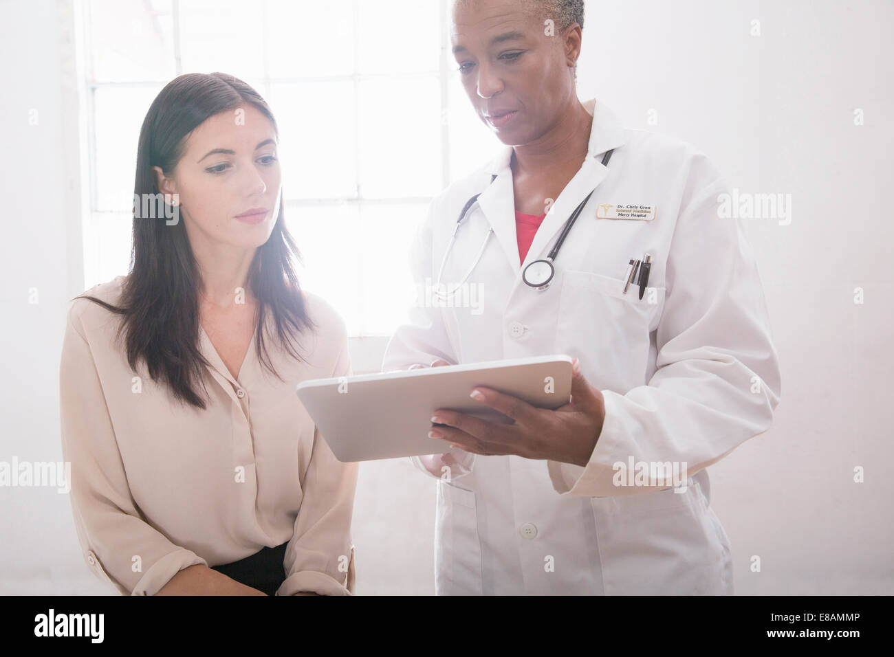 Medico donna utilizzando digitale compressa in consultazione Foto Stock