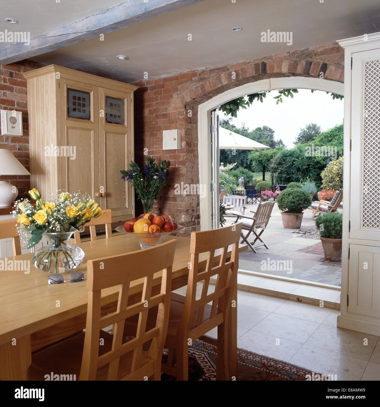 Cornice quadrata sala da pranzo interna di una casa marrone con tavolo in  legno e sedie bianche Foto stock - Alamy