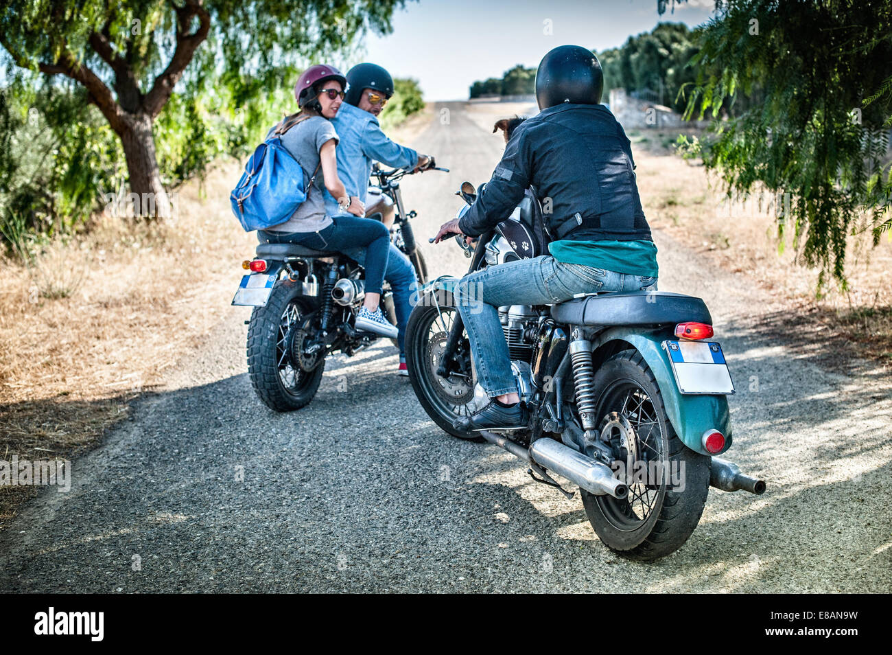 Tre amici e un cane su motocicli, Cagliari, Sardegna, Italia Foto Stock