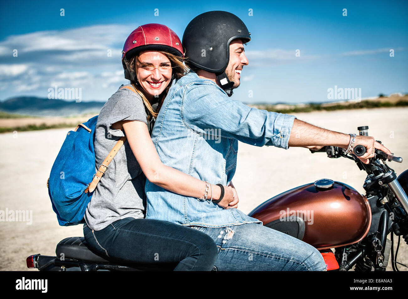 Metà adulto giovane riding motociclo su arida pianura, Cagliari, Sardegna, Italia Foto Stock