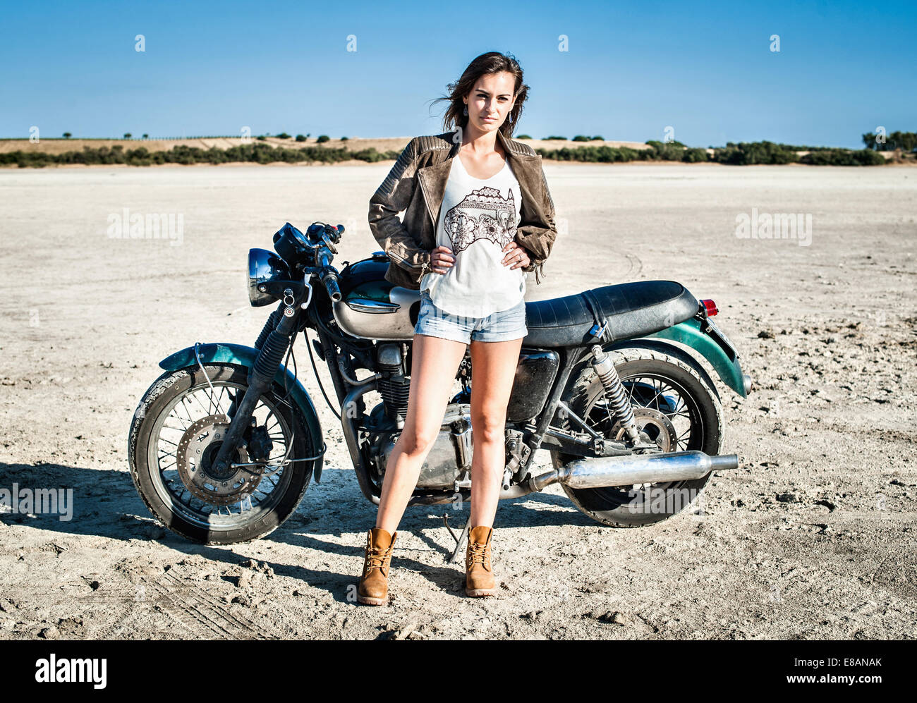 Ritratto di donna motociclista sulla pianura arida, Cagliari, Sardegna, Italia Foto Stock
