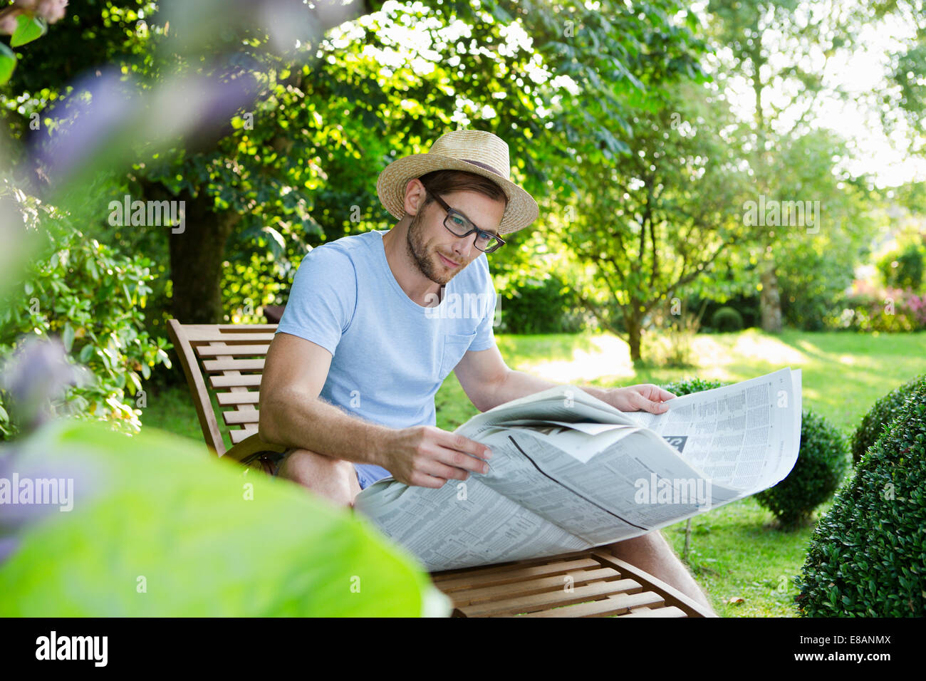 Metà uomo adulto leggendo il giornale in giardino Foto Stock