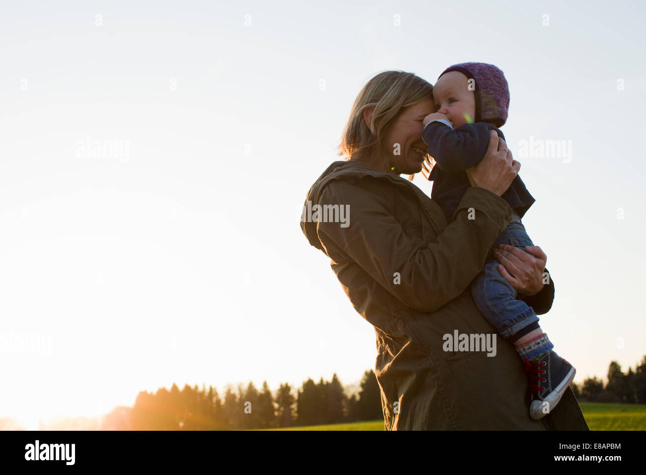 Coppia madre e figlia del bambino nel campo al tramonto Foto Stock