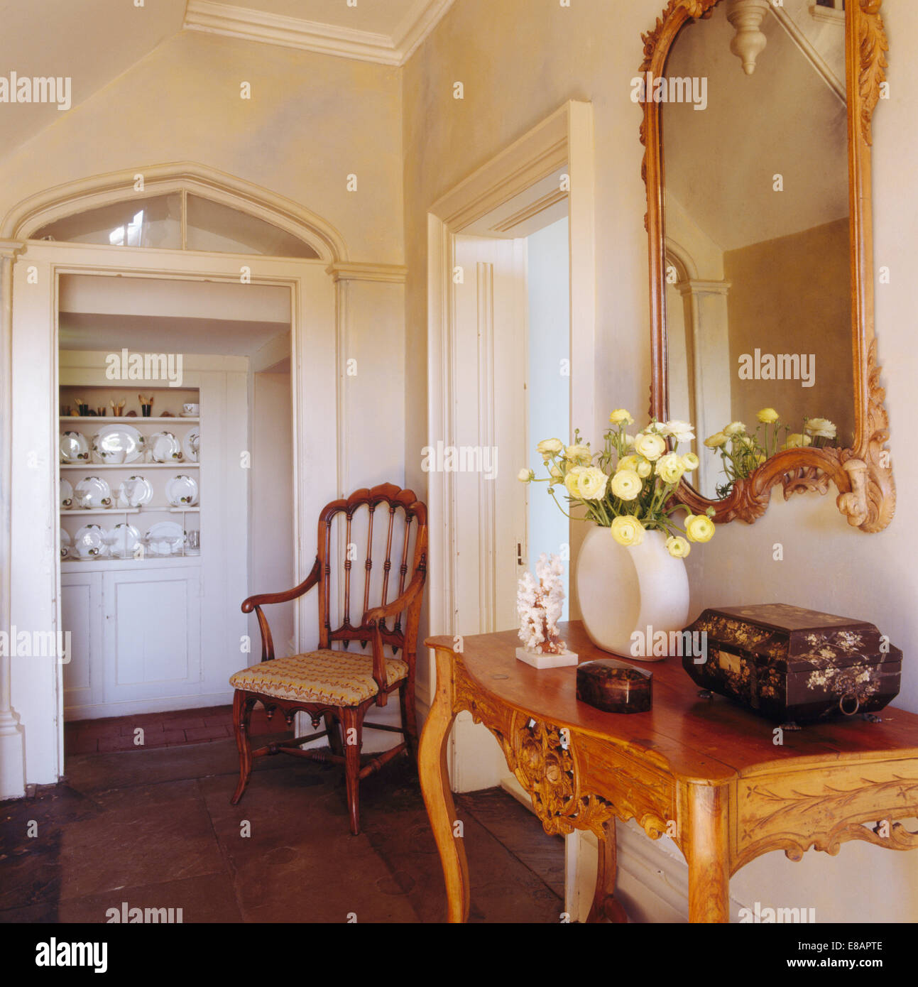 Specchio dorato sopra la console di antiquariato tabella nel paese hall con  sedia antica Foto stock - Alamy
