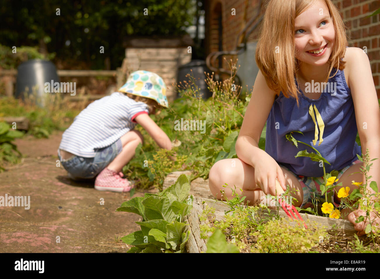 Due sorelle scavando nel giardino Foto Stock