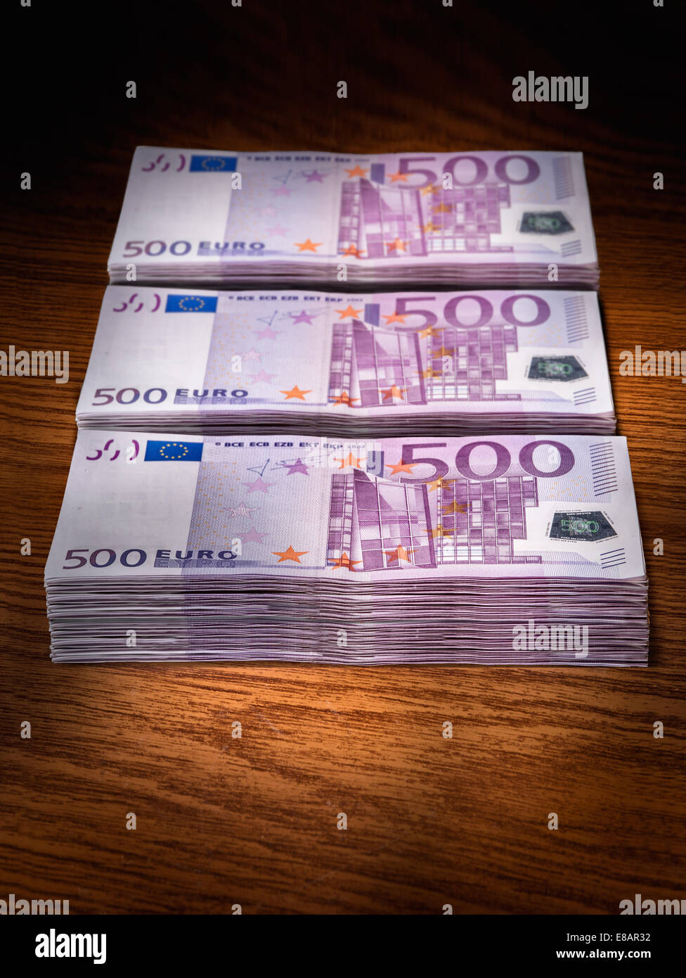 Tre pile di 500 euro bills sulla scrivania in ufficio Foto Stock