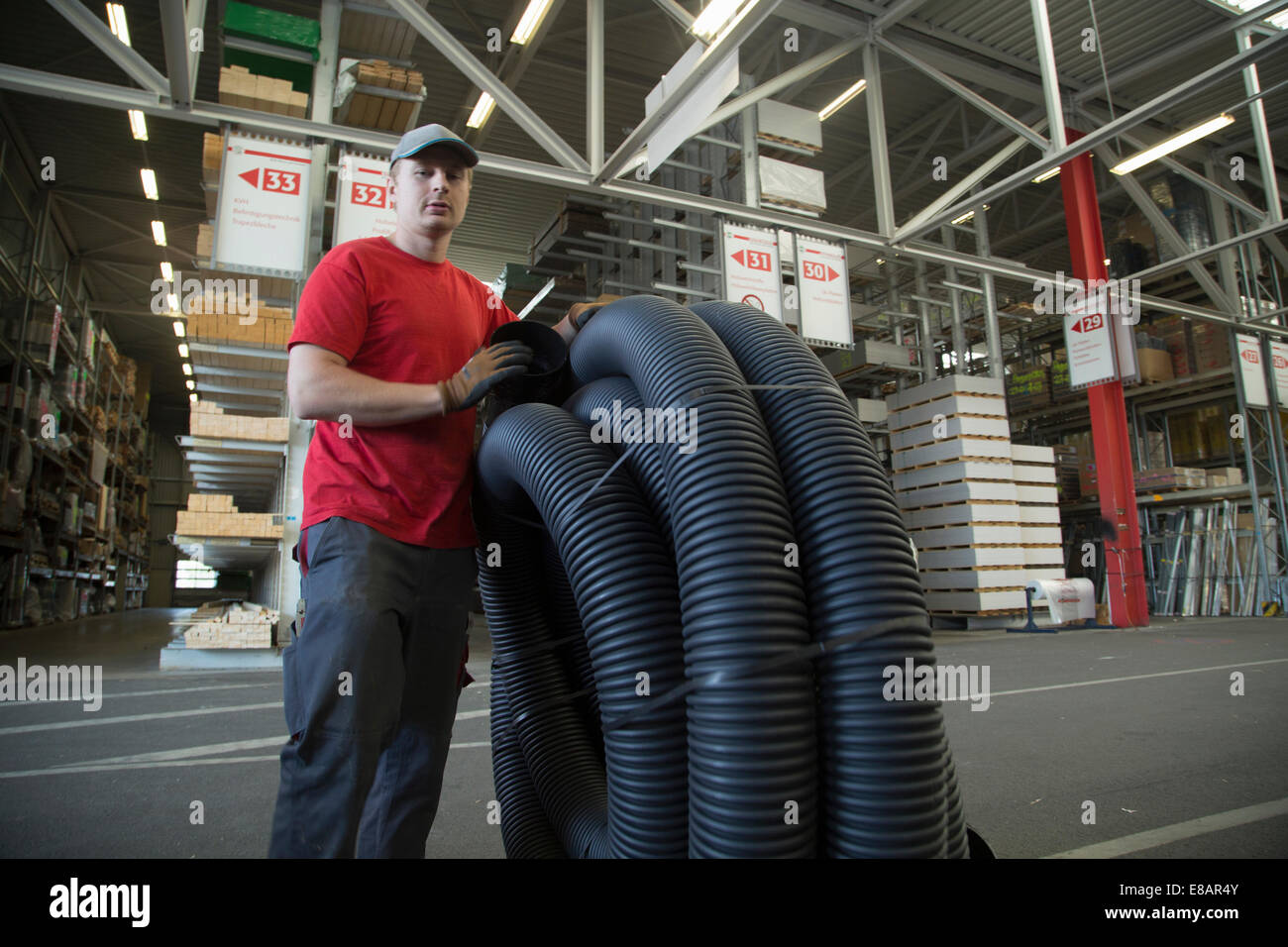 Ritratto di lavoratore con arrotolato piping in negozio di ferramenta magazzino Foto Stock
