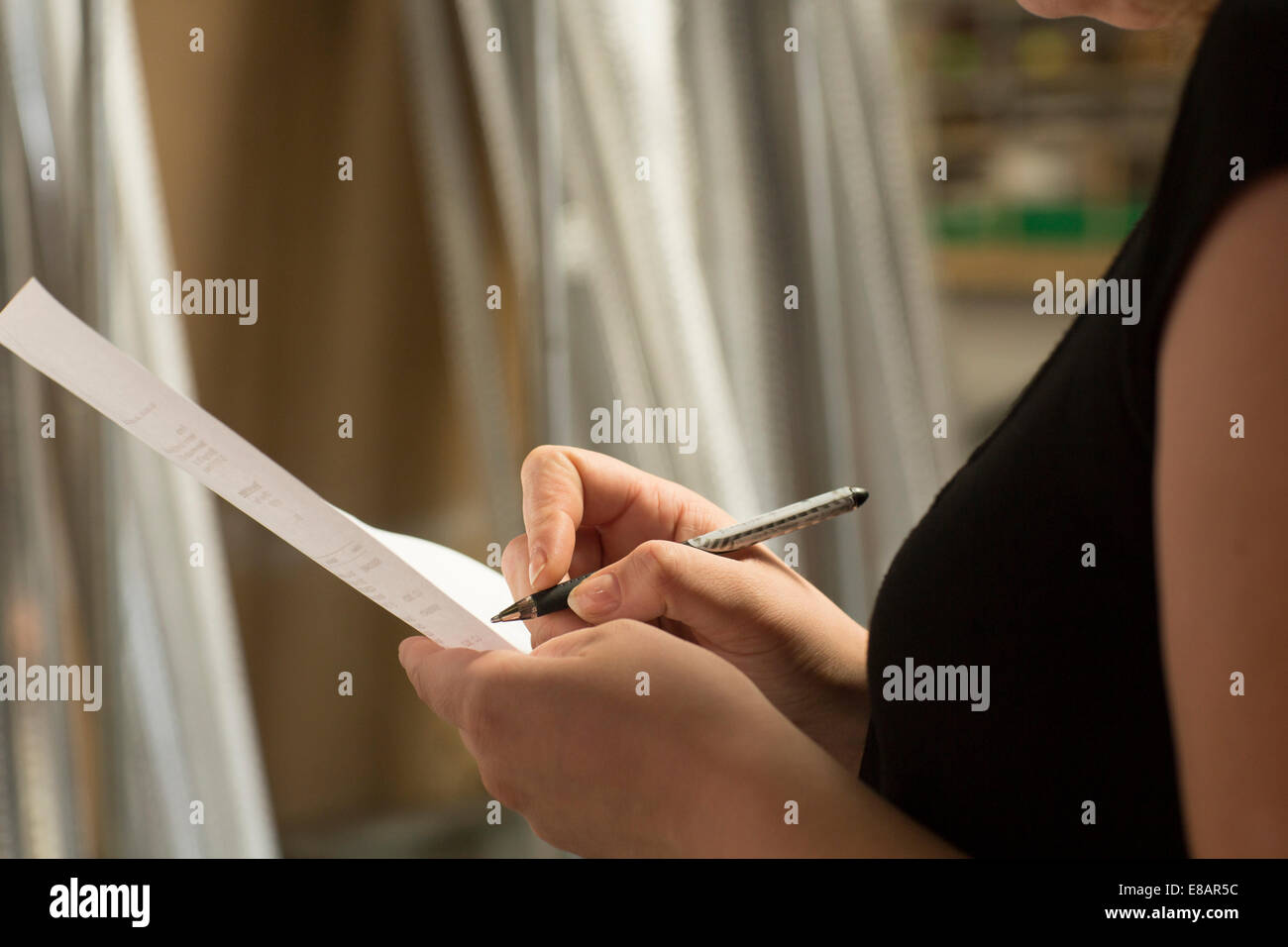 Chiusura del magazzino femmina lavoratore prendendo le scorte in negozio di ferramenta Foto Stock