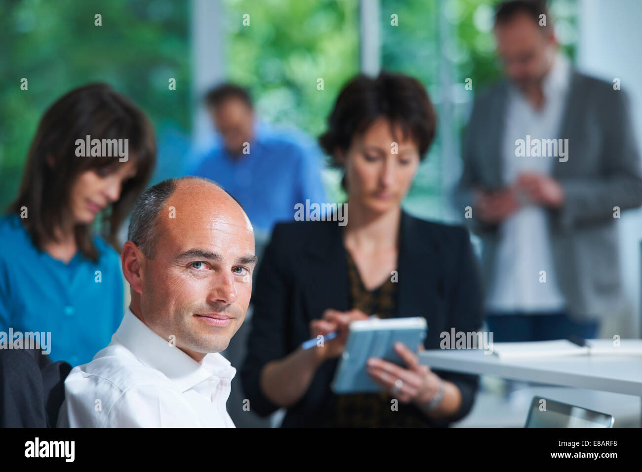Ritratto di imprenditore di fronte ai colleghi in ufficio Foto Stock
