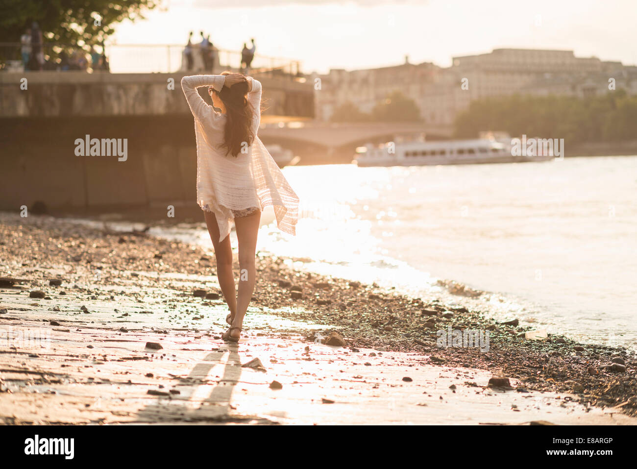 Giovane donna a piedi lungo il fiume Foto Stock