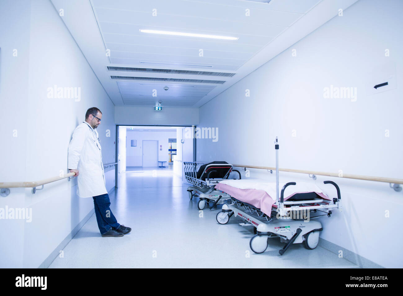 Preoccupato per il medico con la testa in giù nel corridoio di ospedale Foto Stock