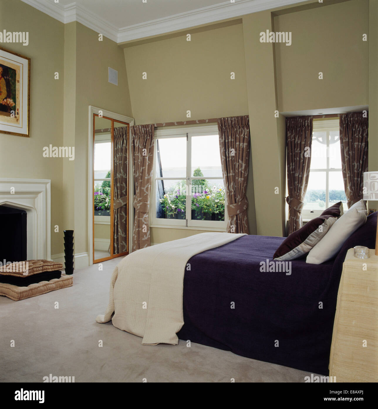 Passi di crema e blu scuro bed-coperchio sul letto in ampio soppalco camera da letto di conversione con tappeto bianco e pareti neutre Foto Stock