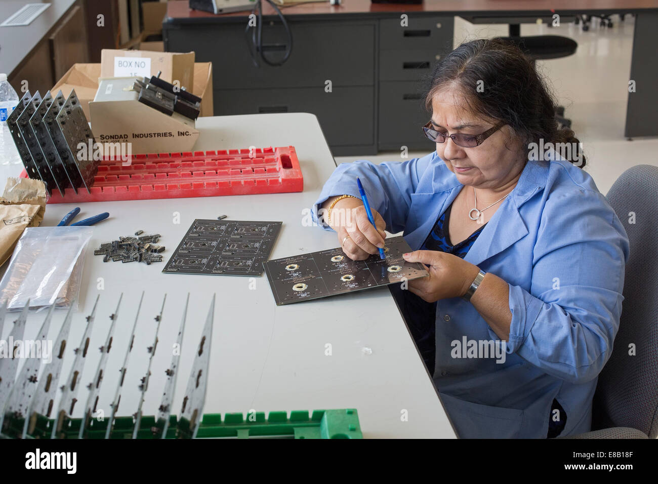 Detroit, Michigan - un lavoratore per un123 sistemi assembla il circuito stampato per veicoli aerei senza equipaggio (droni). Foto Stock Detroit, Michigan - un lavoratore per un123 sistemi assembla il circuito stampato per veicoli aerei senza equipaggio (droni). Foto Stock