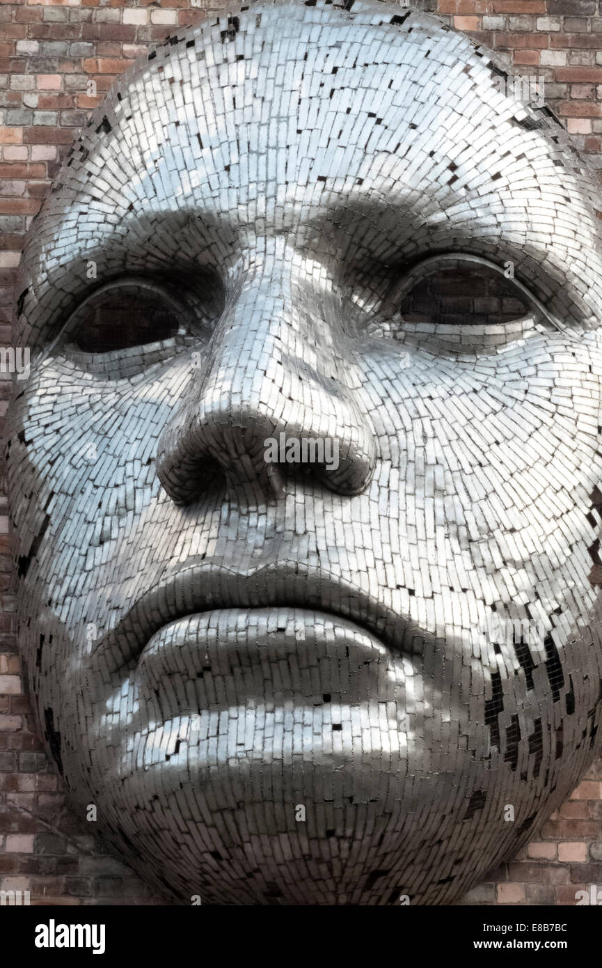 Una faccia di metallo scultura dell'artista Rick Kirby sull'esterno del trapano Hall di Lincoln, Regno Unito. Foto Stock