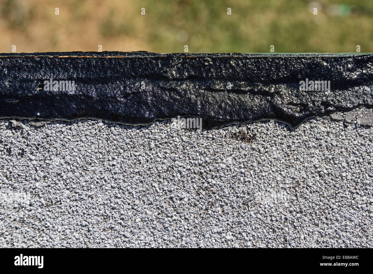 Il catrame fresco tetto patch umido lungo il bordo di un tetto piatto Foto Stock