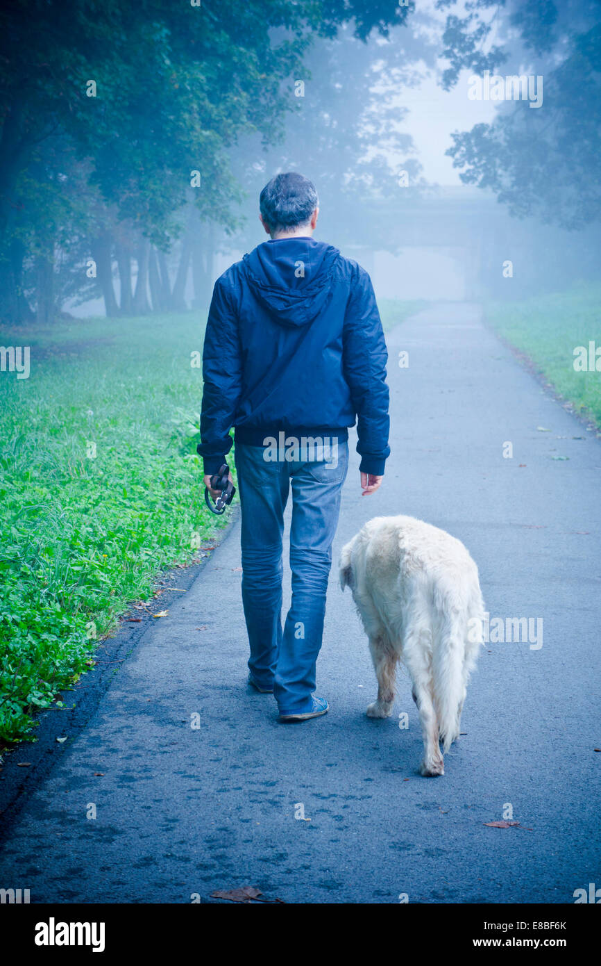 Uomo che cammina con il suo cane nella natura Foto Stock