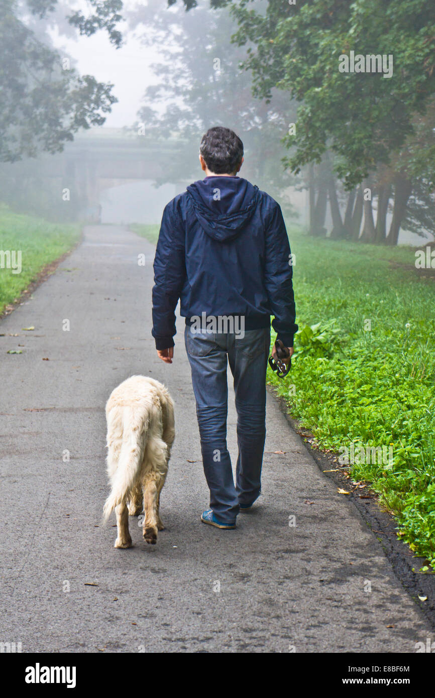 Uomo che cammina con il suo cane nella natura Foto Stock
