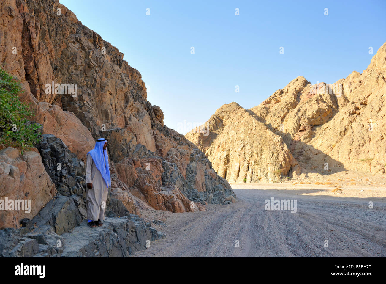 Penisola del Sinai desert via tra le montagne con uomo beduino nel tradizionale thawb accappatoio e testa kufeya ware Foto Stock