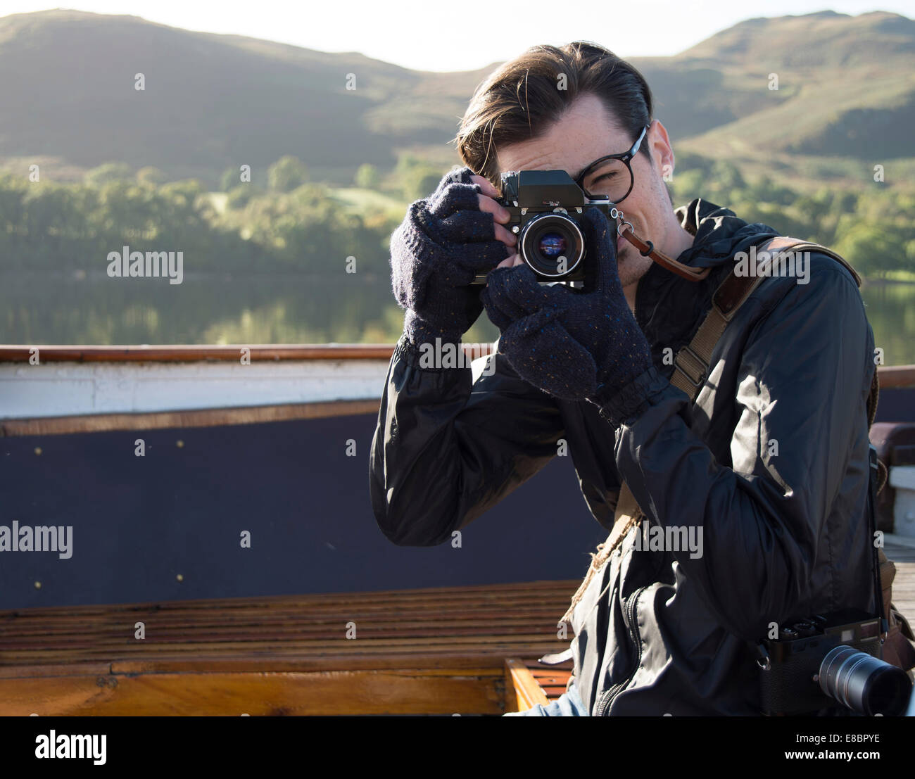Giovane maschio fotografo in un colpo nel Lake District inglese. Foto Stock