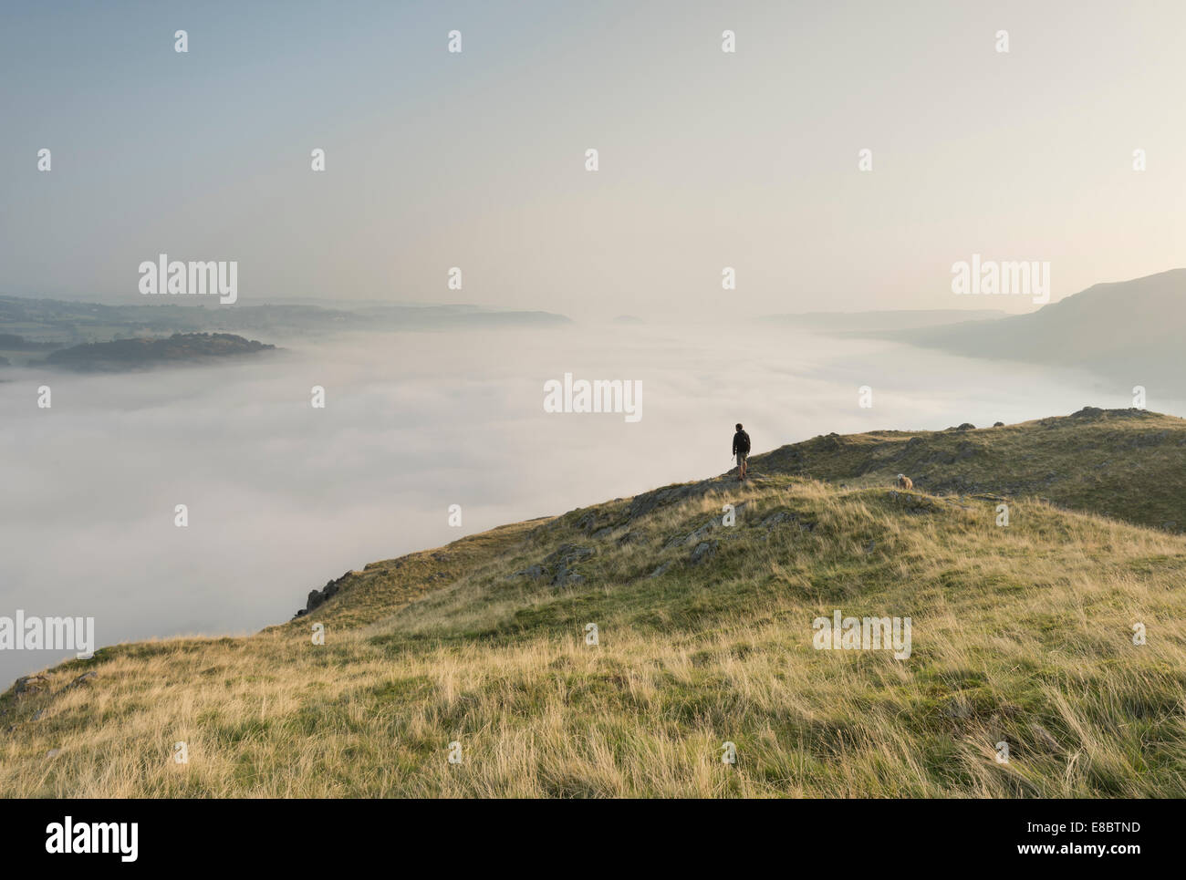 Il camminatore solitario sul Hallin è sceso al di sopra di una temperatura al di sopra di inversione Ullswater nel Lake District inglese Foto Stock