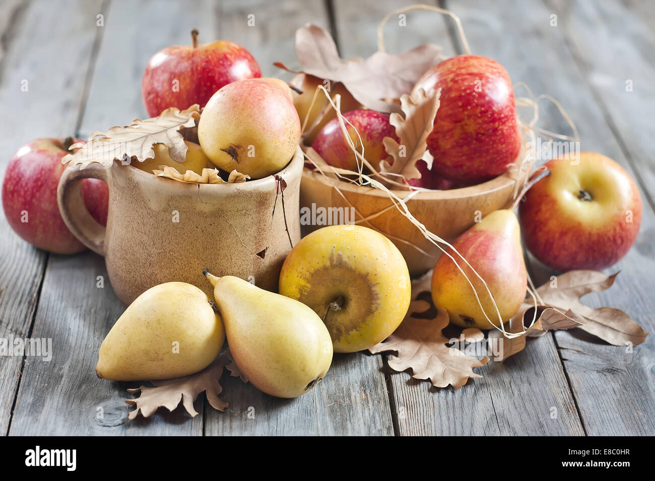 Pere e mele a secco con caduta foglie su sfondo di legno. Messa a fuoco selettiva. Foto Stock