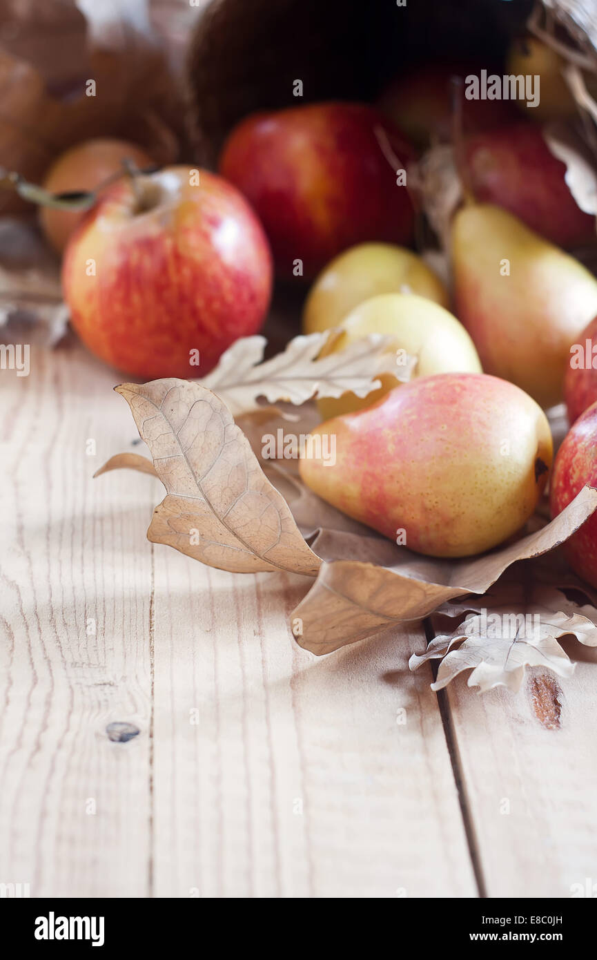 Pere e mele a secco con caduta foglie su sfondo di legno. Messa a fuoco selettiva. Copyspace sfondo. Foto Stock