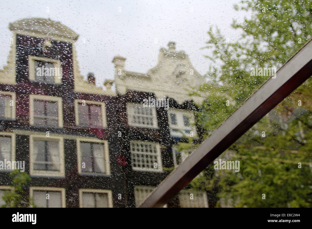 Amsterdam facciate di case attraverso le gocce di pioggia sulla finestra. La città capitale olandese. Foto Stock