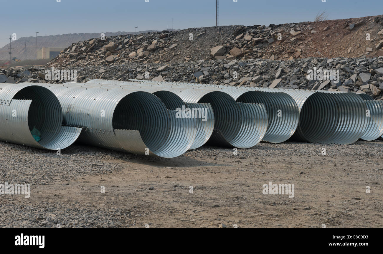 Una linea di acciaio ondulato canali sotterranei di sedersi a fissare in area pronto per essere installato sotto le strade in una miniera a cielo aperto. Foto Stock