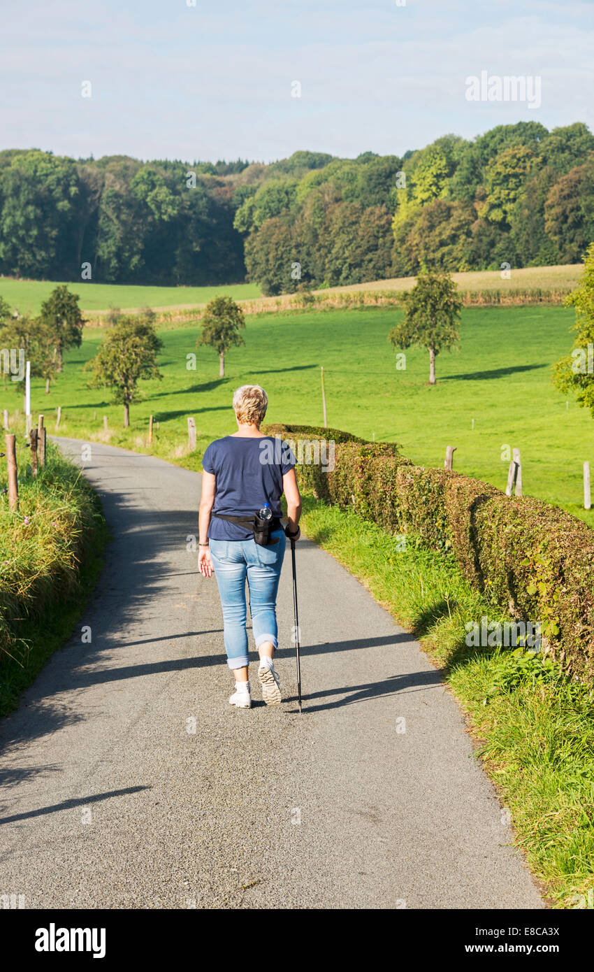 La donna a piedi nella natura con bottiglia di acqua sulla sua schiena Foto Stock