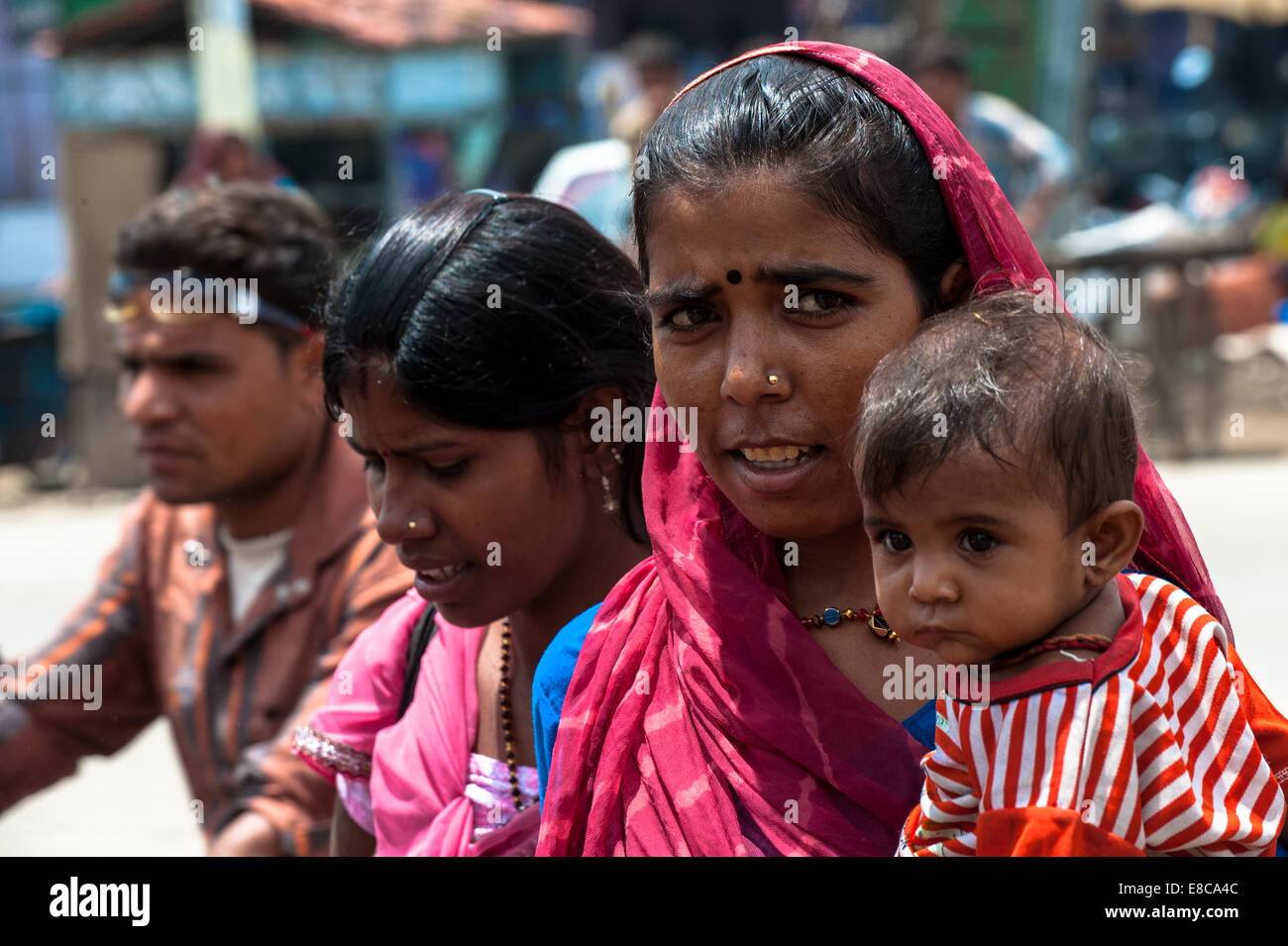 La vita rurale nel Rajasthan, Donna in tradizionali abiti colorati con bambino Foto Stock
