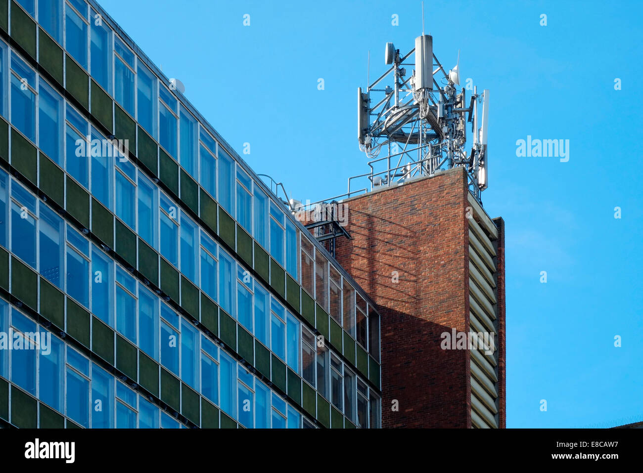 Telefono mobile e le apparecchiature di telecomunicazione montato sulla parte superiore di un edificio del centro Inghilterra Regno Unito Foto Stock