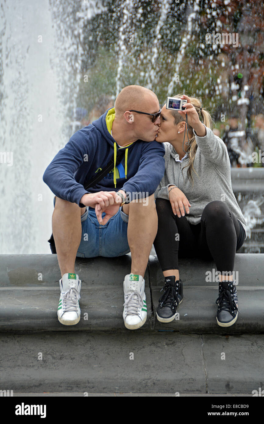Un paio di baciare prendendo un selfie vicino alla fontana di Washington Square Park nel Greenwich Village di New York City Foto Stock