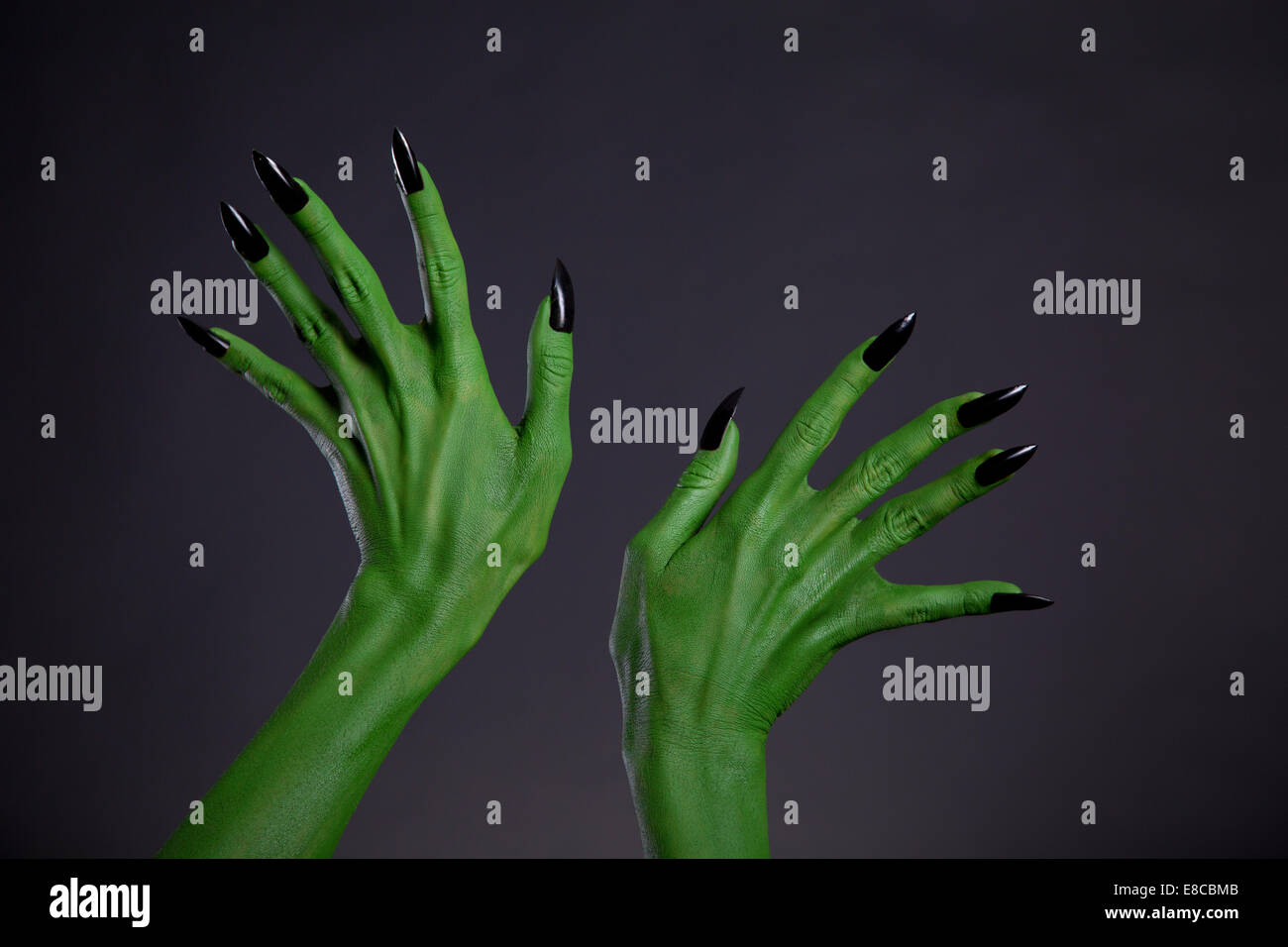 Green monster mani con unghie nere, tema Halloween, studio shot su sfondo nero Foto Stock