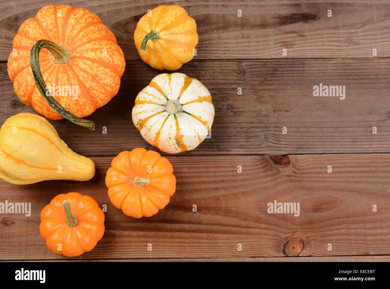 Un autunno decorativo ancora in vita di mini zucche e zucche su una tavola in legno rustico. Formato orizzontale con copia spazio. Foto Stock