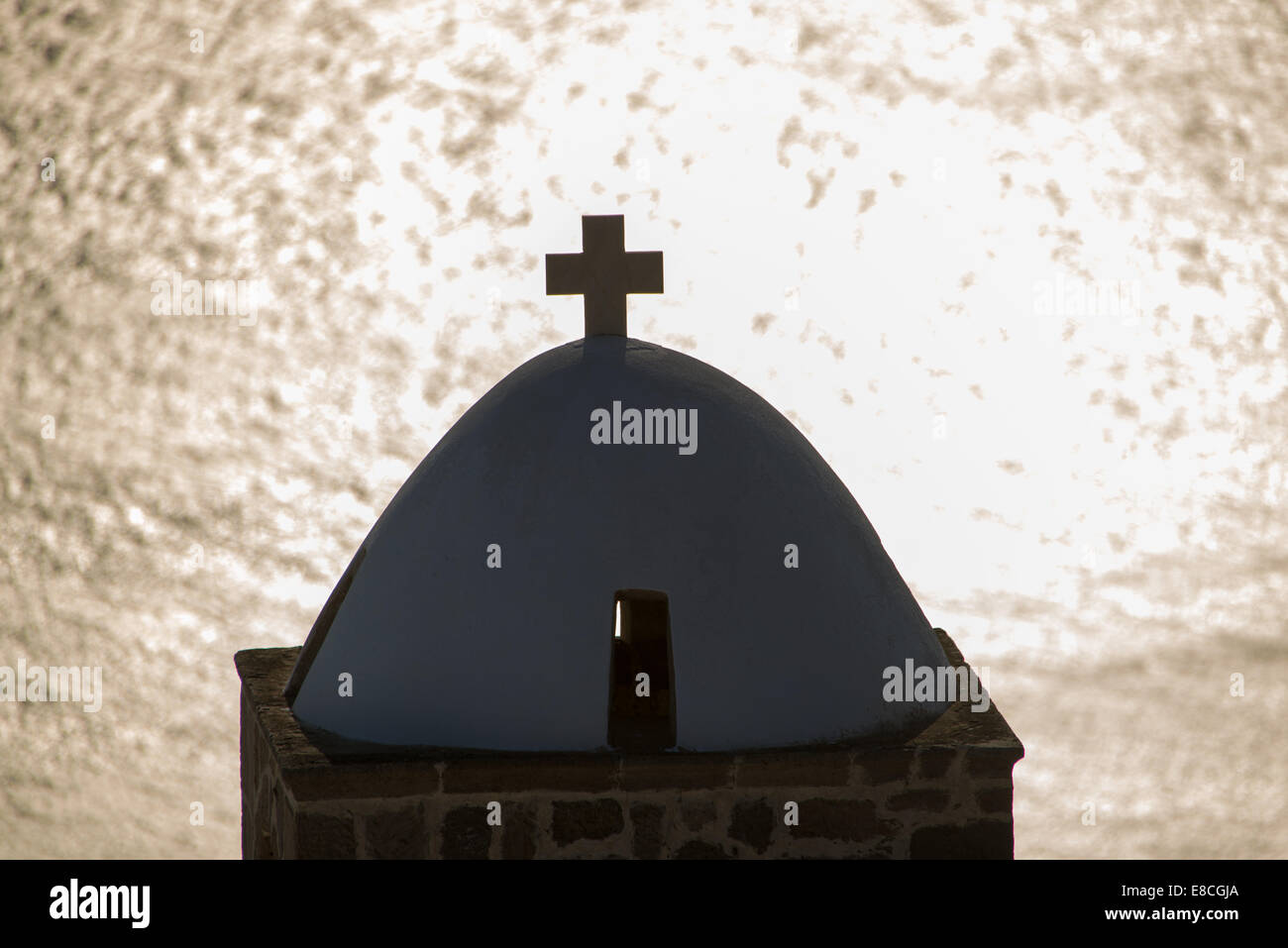 Silhouette del campanile e di riflessione in mare a Plaka, Milos, Grecia Foto Stock