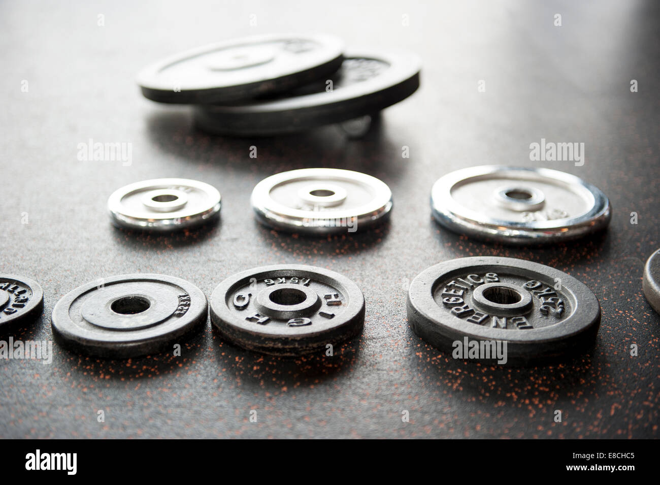 Raccolta di peso di manubri piastre disposte sul pavimento nero in breve dept del campo Foto Stock