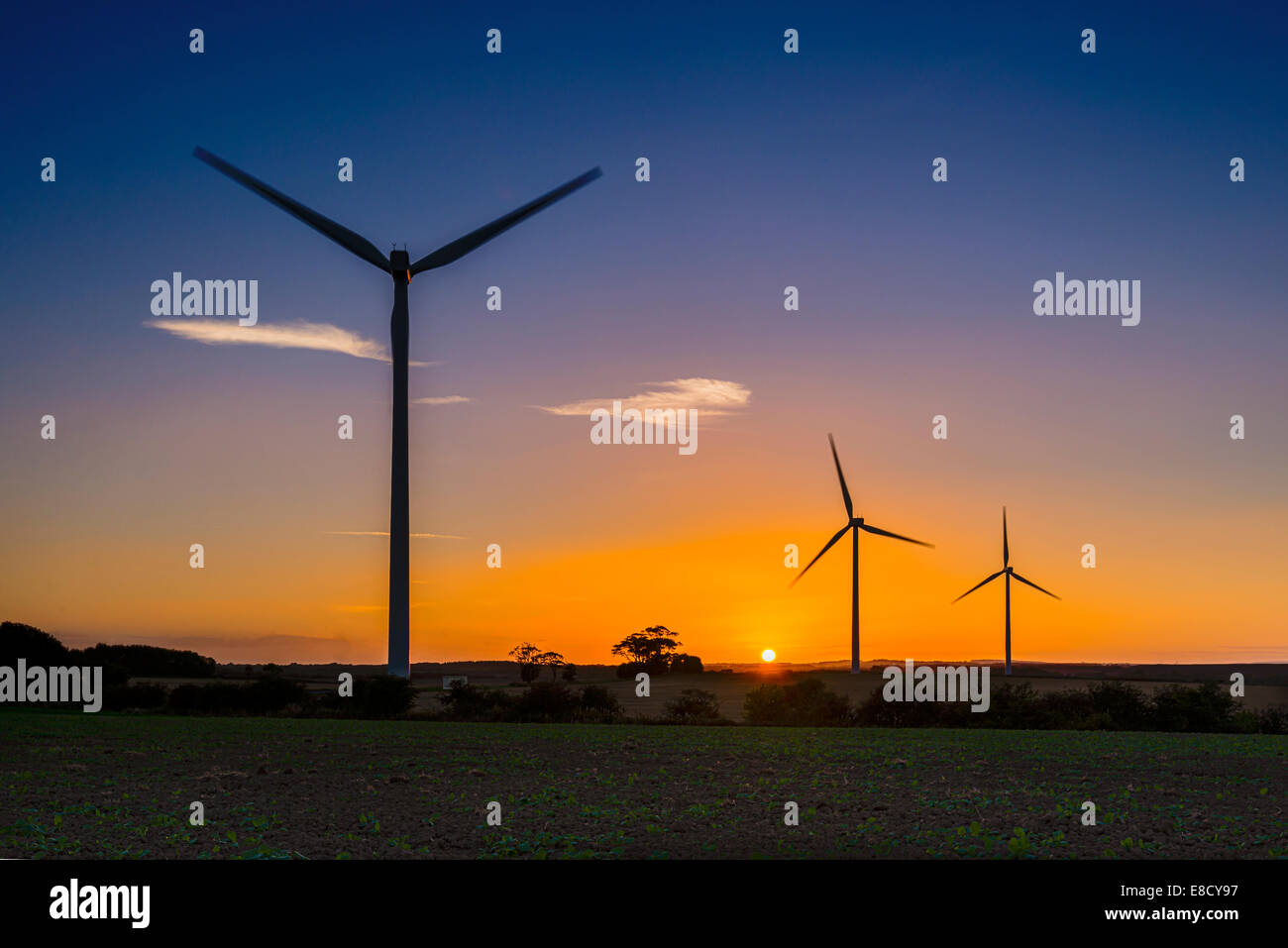 Fila di tre turbine eoliche al tramonto vicino Lynemouth, Inghilterra Foto Stock