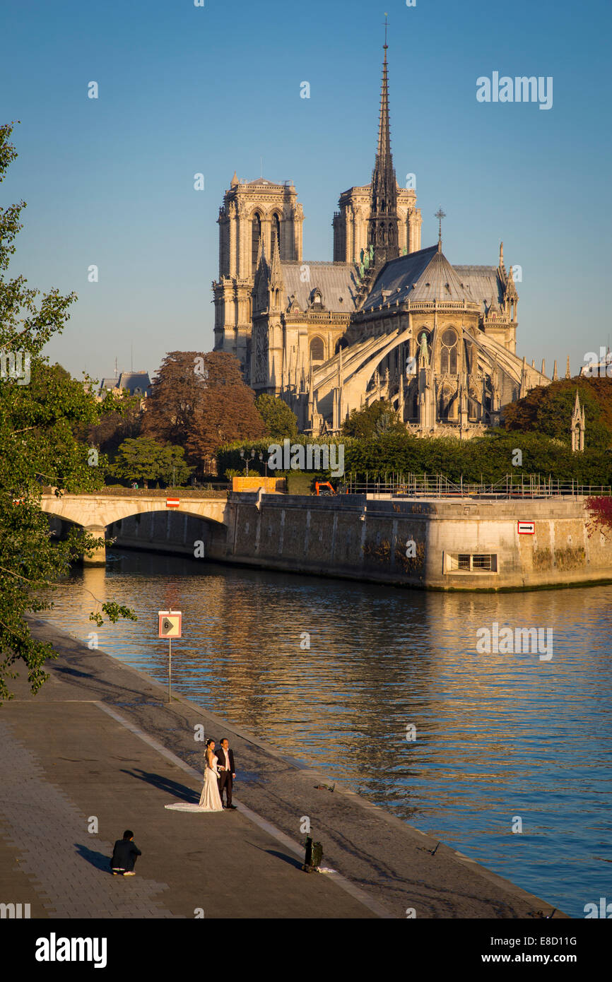 Coppie in viaggio di nozze in posa per la mattina presto le foto di seguito Cattedrale di Notre Dame, Paris, Francia Foto Stock