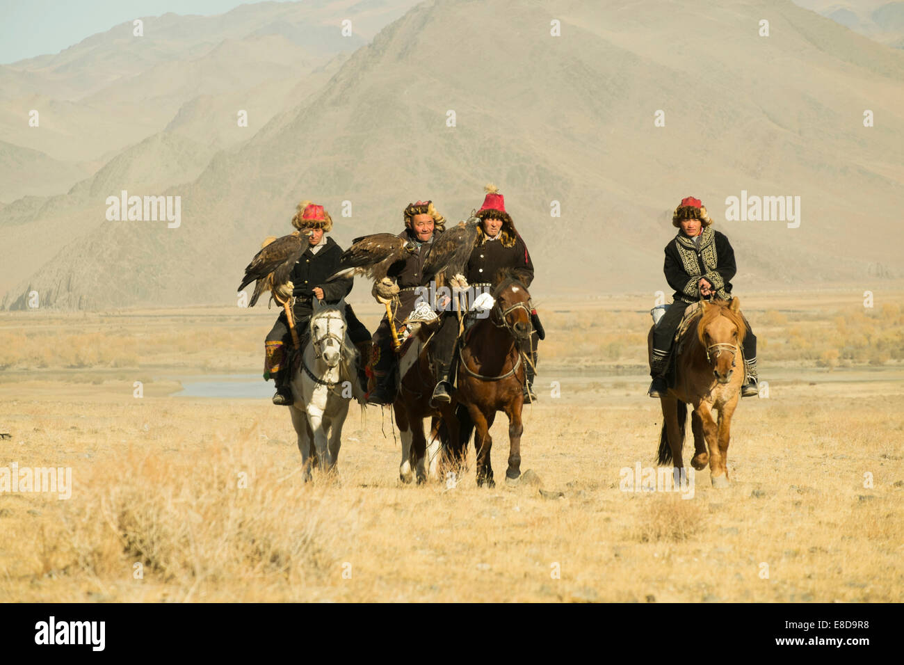 Quattro aquila kazaka cacciatori su i loro cavalli sul modo di l'Aquila Festival di Sagsai, Bayan-Oelgii Aimag, Mongolia Foto Stock