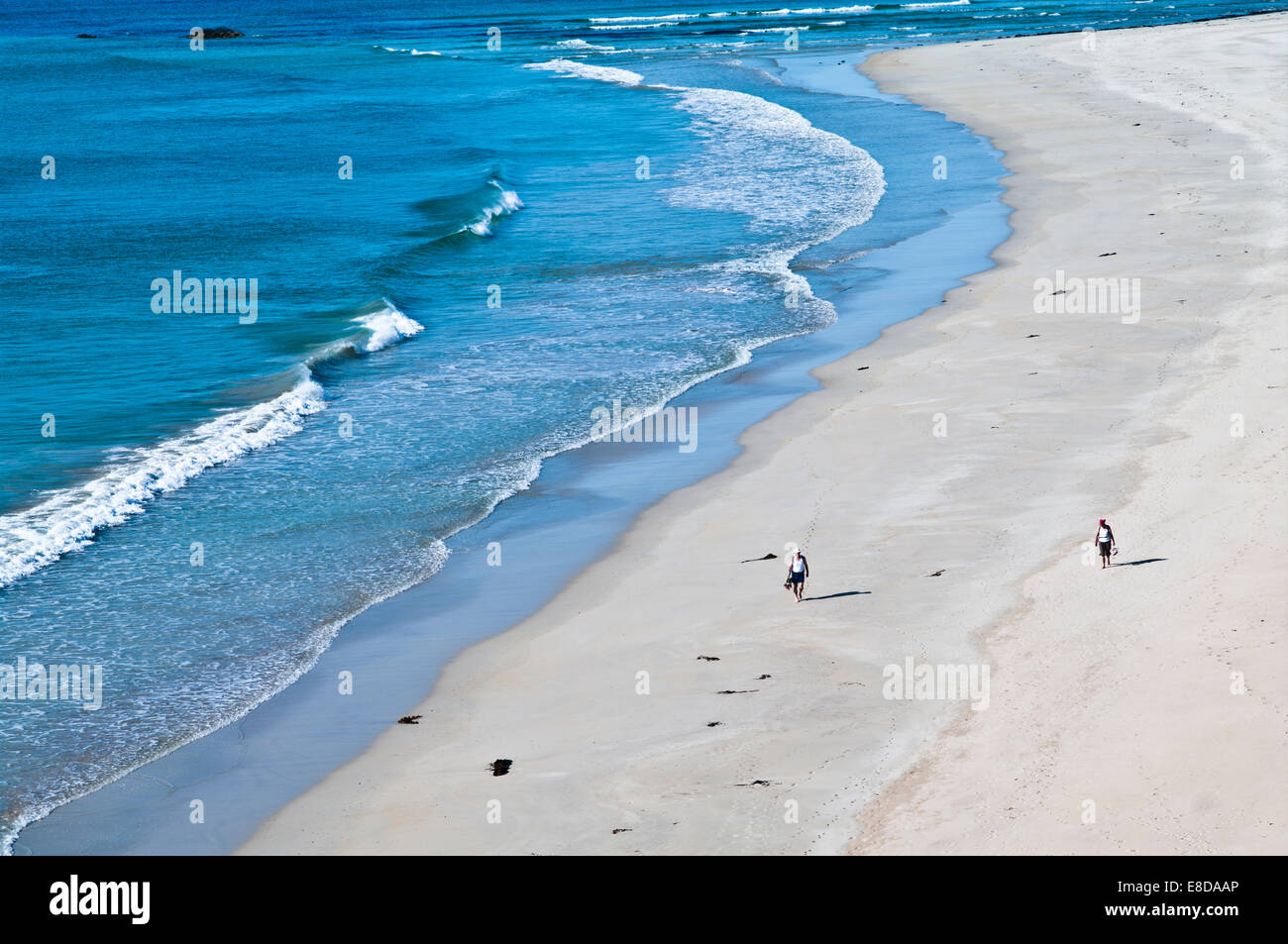 Giovane camminare a piedi scalzi lungo una bellissima spiaggia di sabbia sul bordo dell'acqua, caldo sole estivo, Balnakeil Bay Sutherland Scozia Scotland Foto Stock