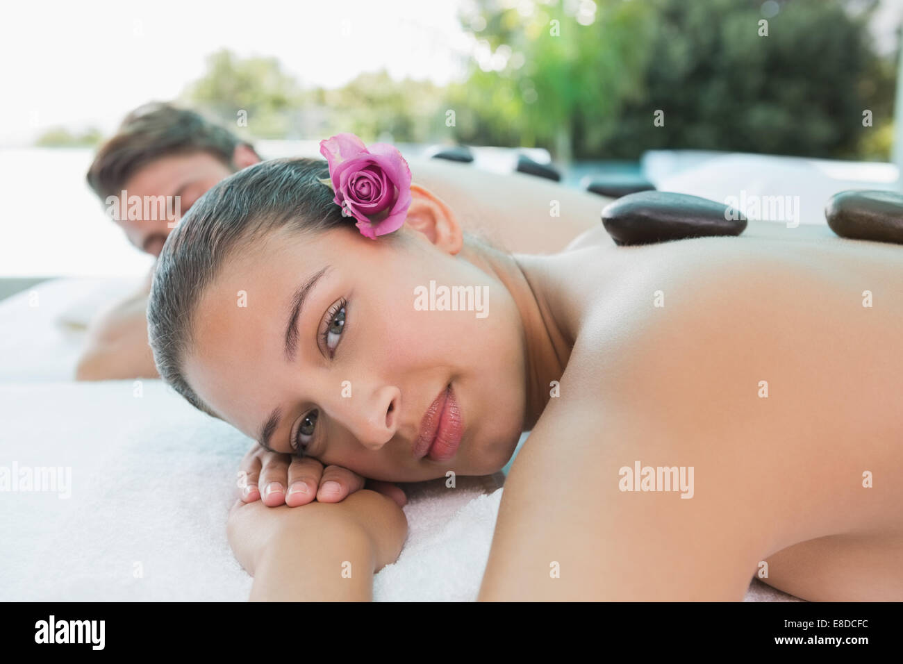 Giovane godendo stone massage a health farm Foto Stock