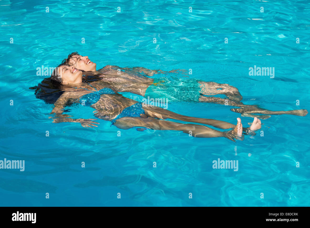 Rilassata coppia giovane in piscina Foto Stock